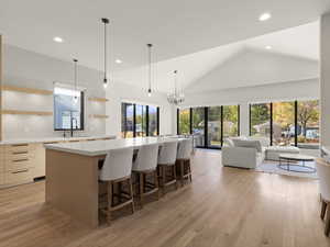 Kitchen with open shelves, pendant lighting, a spacious island, recessed lighting, and light wood-style flooring