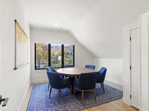Dining room with light wood finished floors, lofted ceiling, recessed lighting, and a mountain view