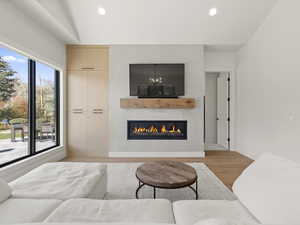 Living room featuring light wood-style floors, a large fireplace, and recessed lighting