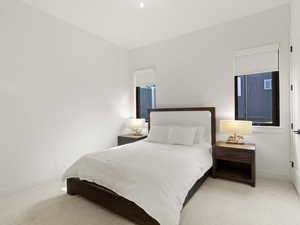 Bedroom featuring light carpet and baseboards