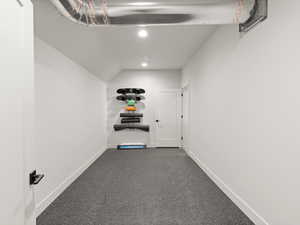 Hallway featuring dark carpet, recessed lighting, and vaulted ceiling