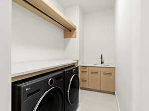 Washroom with washer and dryer and light tile patterned floors