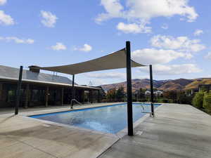 Community pool with a patio area and a mountain view