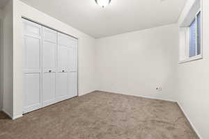 Unfurnished bedroom with carpet flooring and a closet