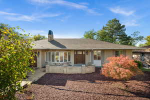 Ranch-style house with brick siding, a shingled roof, and a chimney