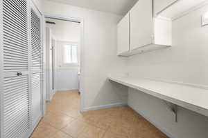 Laundry room with light tile patterned floors and baseboards