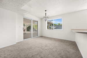 Unfurnished dining area with a textured ceiling and carpet