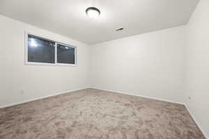 Empty room featuring carpet flooring and baseboards