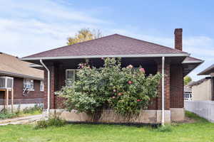 View of front of house with a chimney, brick siding