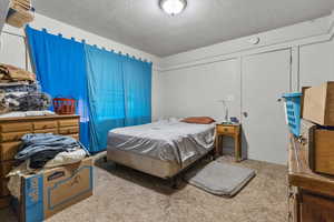 Bedroom featuring a textured ceiling and carpet