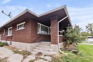 View of side of the front porch of home featuring brick siding