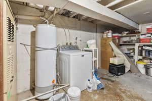 Unfinished below grade area with washer / dryer and gas water heater