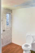 Bathroom with dark wood-style flooring and baseboards