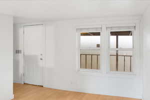 Spare room featuring light wood finished floors and baseboards
