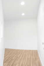 Empty room with light wood-style flooring and recessed lighting
