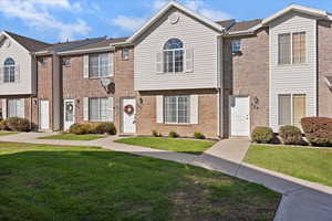View of front of house with a front lawn and brick siding