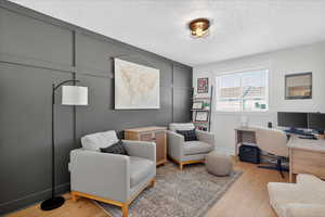 Office space with light wood-style floors and a textured ceiling