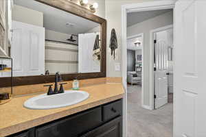 Full bath with vanity, a shower with curtain, light carpet, and a textured ceiling