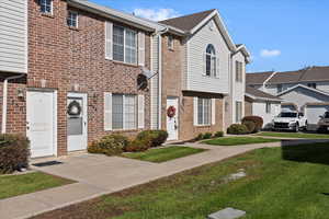 View of front of property featuring a front lawn and brick siding