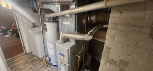 Utility room featuring washer / dryer, gas water heater, and heating unit