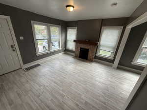 Unfurnished living room with a fireplace and light wood finished floors