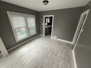 Unfurnished bedroom with light wood-style floors and ensuite bathroom
