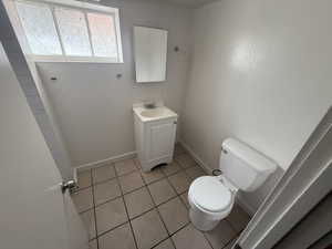 Half bathroom with light tile patterned flooring and vanity