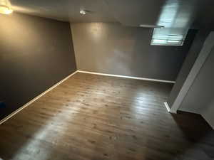 Basement with dark wood-style floors and baseboards
