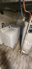 Laundry area with water heater, light wood-style flooring, and washing machine and clothes dryer
