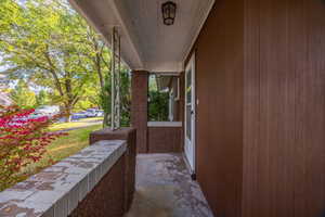 Covered porch featuring a yard