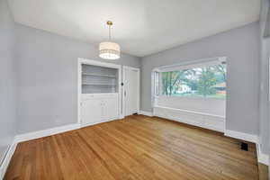 Dining area with light wood finished floors, built in storage with window seat.