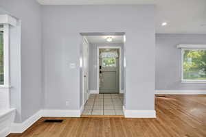 Foyer with light wood flooring and recessed lighting