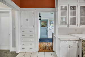 Kitchen featuring white cabinets, light countertops, light tile patterned floors, and glass insert cabinets