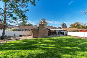 Rear view of property with a patio area, a fenced backyard, and a chimney