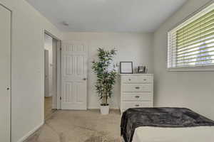 Bedroom featuring light colored carpet and baseboards