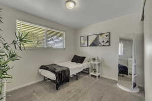 Bedroom featuring light colored carpet and baseboards