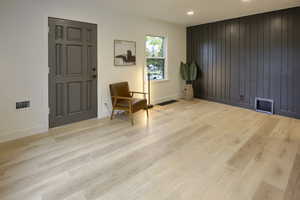 Living area with wood finished floors and wood walls