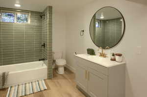 Bathroom featuring vanity, light wood-type flooring, and shower / washtub combination