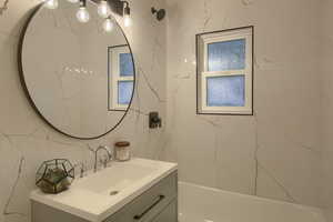 Bathroom with vanity and bathing tub / shower combination