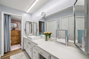 3/4 bathroom featuring vanity, light wood finished floors, and an enclosed shower