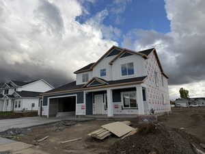 Property under construction featuring board and batten siding and concrete driveway