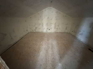 Additional living space featuring vaulted ceiling and a textured ceiling