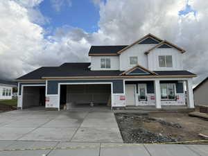 View of front facade with board and batten siding, driveway, a porch, and an attached garage