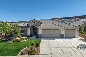 French provincial home with a garage, stone siding, concrete driveway, a front yard, and stucco siding