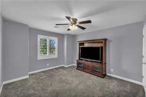 Unfurnished living room with carpet floors and a ceiling fan