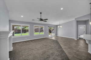 Unfurnished living room with ceiling fan, vaulted ceiling, tile patterned floors, a chandelier, and recessed lighting