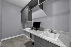 Home office with baseboards and light stone finish flooring