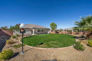 Back of house with a fenced backyard and stucco siding