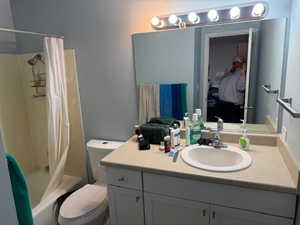 Full bath with shower / tub combo with curtain and vanity