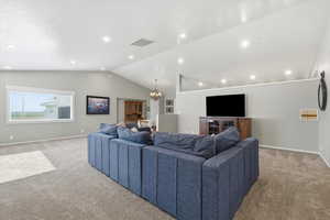 Living room featuring a chandelier, carpet flooring, vaulted ceiling, and recessed lighting